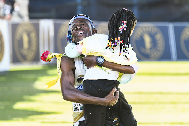 Gift Kelehe is greeted by his daughter as he finishes in ninth place in the 2023 Comrades Marathon at Kingsmead Stadium in Durban on June 11 2023.