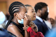 A boy comforts a crying woman during a sombre memorial service for two Lesiba High School pupils, Njabulo Ndhlebe and Zukisa Majola, who died in a tragic shooting incident on the first day of school last week in Daveyton, Ekurhuleni.