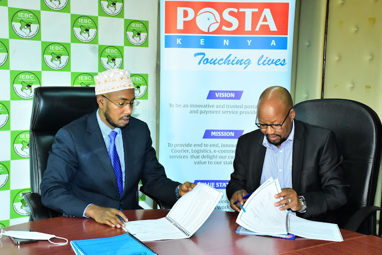 IEBC chief executive officer Marjan Hussein Marjan, Postal Corporation of Kenya CEO and Postmaster general Dan Kagwe sign a multi-million agreement for the provision of logistics services during the election on April 4.