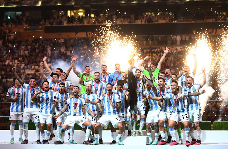 Argentina's Lionel Messi and his teammates celebrate with the trophy after winning the 2022 World Cup at Lusail Stadium in Lusail, Qatar on December 18 2022.