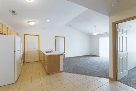 Kitchen and dinning room with tile floor, white appliances in kitchen, light wood cabinets. Living room with grey carpet