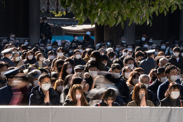 TOKYO, JAPAN - JANUARY 01: People pray for good luck in the new year at Meiji Shrine on January 01, 2023 in Tokyo, Japan. People in Tokyo celebrated the arrival of the new year, the first since pandemic restrictions were completely removed in 2022.