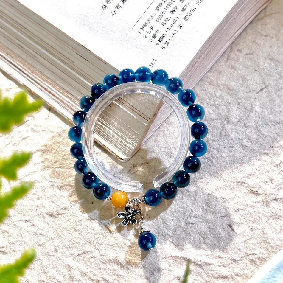 Bracelet en agate cœur de sucre bleu avec petit pendentif fleur, un bijou délicat pour sublimer votre poignet avec une touche naturelle.