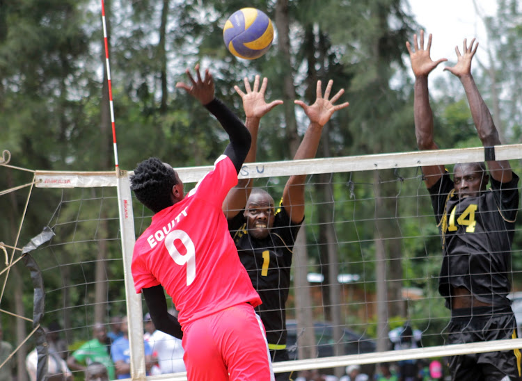 Equity Bank's James Mutero (red) attacks the ball past the blocks of GSU's Shadrack Misiko (Black) and David Kirwa (Black) during Arthur Odera Cup in Malaba.