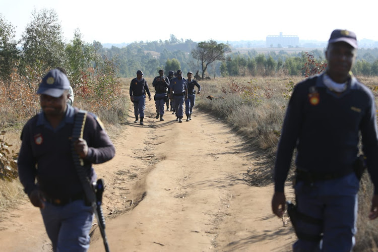 Police strolled through parts of Mohlakeng, Randfontein, on Tuesday as they searched for zama zamas. The area was thrown into chaos on Monday as communities torched the homes of alleged zama zamas.