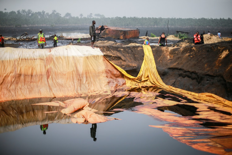 Member of the task force on illegal crude oil bunkering and artisanal refinery stand around a dug crude storage facility during the destruction of Bakana ii camp in Okrika, Nigeria January 28 2022. File photo.