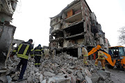 Rescuers work at a residential building damaged during Ukraine-Russia conflict in the southern port city of Mariupol, Ukraine April 19, 2022. 