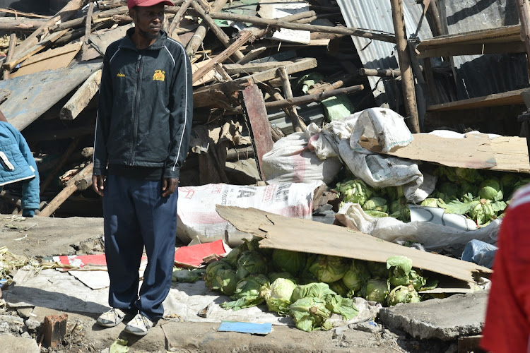 A hopeless man stands aside where he used to sell cabbages in his kiosk at Mukuru kwa Njenga on November 13, 2021