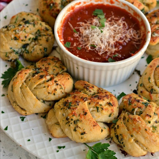 These delectable Garlic Knots are made easy using already made fresh or refrigerated canned pizza dough.  They can be prepped and in the oven in less than 10 minutes.  