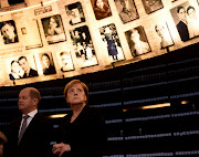 German Chancellor Angela Merkel looks at pictures of Jews killed in the Holocaust during a visit to the Hall of Names in the Holocaust History Museum at the Yad Vashem World Holocaust Remembrance Center in Jerusalem October 4, 2018. 