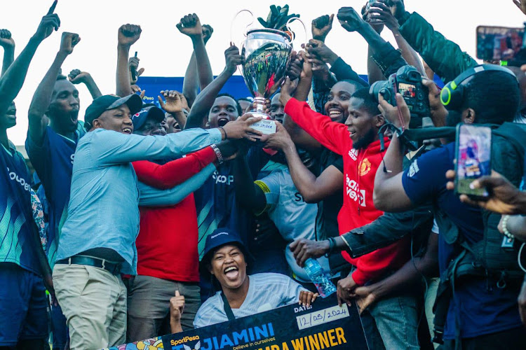 Kanuni MCA Joshat Mugambi (with cap) celebrates with Ikuu Spider FC from Kanuni ward Igembe South constituency on Sunday after they won against Al Azizia FC in the Tujiamini Cheza Dimba Football Tournament at Kinoru Stadium in Meru County