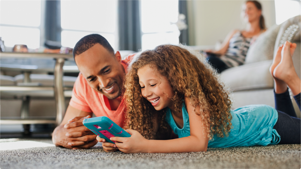 Father and his daughter looking at a mobile phone together