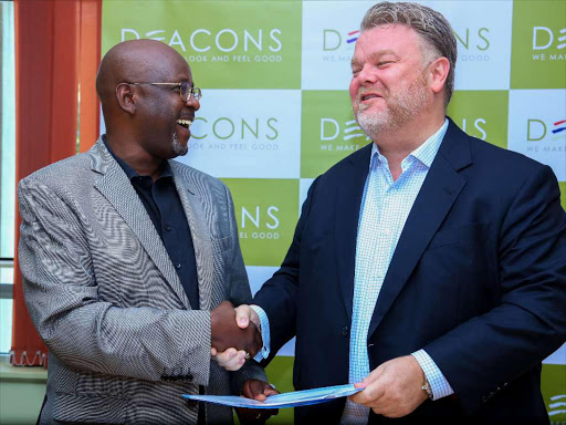 Deacons East Africa chief executive Wahome Mutahi with F&F Global partnerships managing director Marcus Chipchase at the signing of a partnership deal in Nairobi on December 15,2016. /ENOS TECHE.