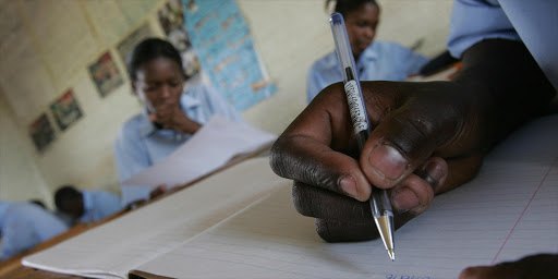 TO GO WITH AFP STORY BY CHARLOTTE PLANTIVE Students at Ibhongo High School, in the heart of South Africa's biggest township Soweto, in class, 16 January 2008. Last year, only a third of Ibhongo's students passed their final matriculation exams against a national average of 65 percent. Despite its status as Africa's largest economy, such tales of social deprivation are common in a country where 43 percent of the population live below the poverty line, mainly in rural areas or townships such as Soweto which is on the outskirts of Johannesburg. "Education in South Afica is shown to be in crisis. Seventy percent of our schools are not functioning," says Graeme Bloch, a specialist in education from the Development Bank of Southern Africa. "It's not a crisis in that that it is falling apart, but kids who are going to school are not learning anything. It doesn't provide skills to our fast-growing economy and it reinforces the divisions of the past.". AFP PHOTO ALEXANDER JOE (Photo credit should read ALEXANDER JOE/AFP/Getty Images)