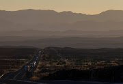 Trucks transport goods from the coast as the sun sets near Laingsburg in the Karoo in this file picture taken October 28, 2013.