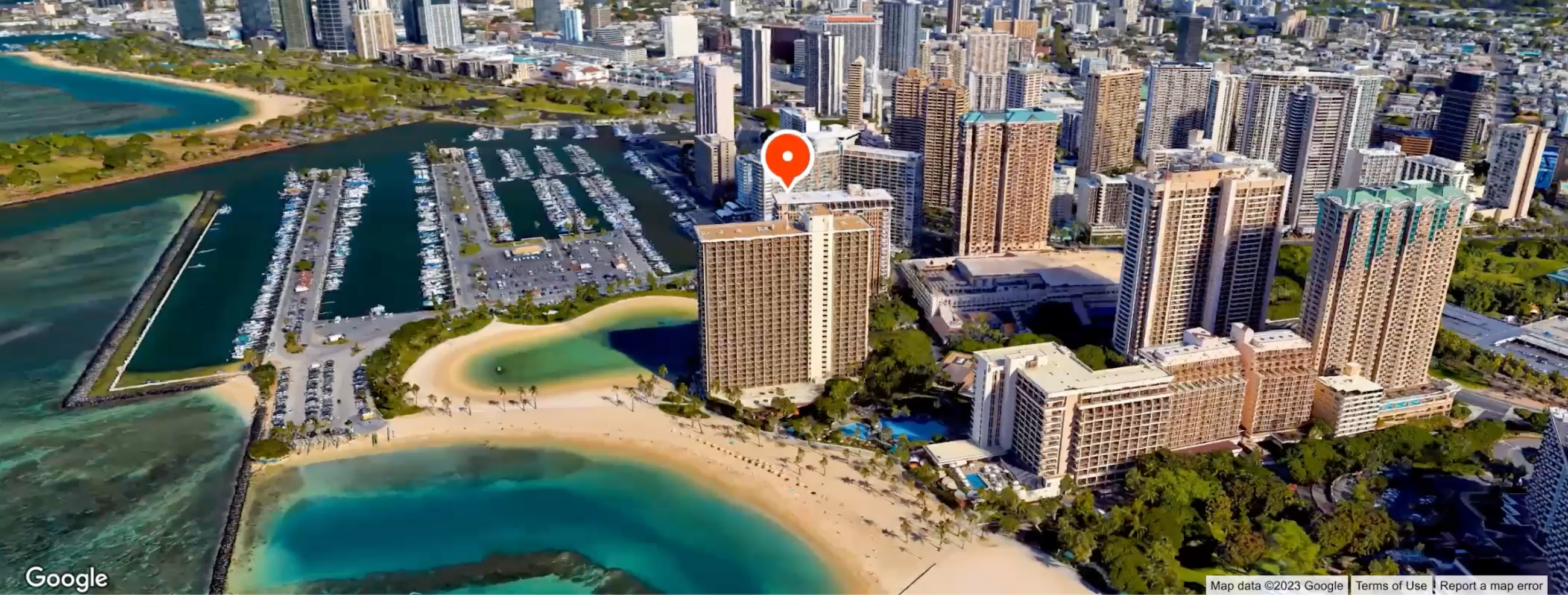 Aerial view of a cityscape with a map pin atop a tall building