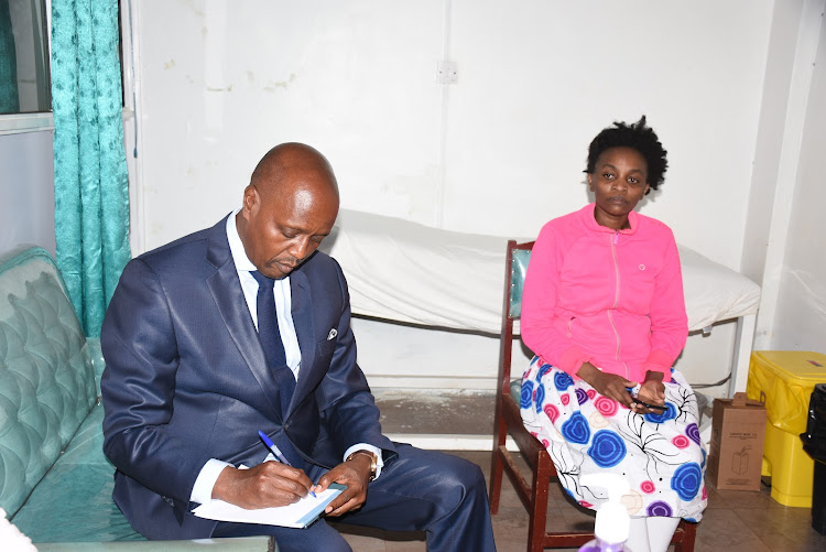 Kiambu MP Machua Waithaka writes some notes while with Tracy Waithera who had incurred a hospital which was offset by President william Ruto