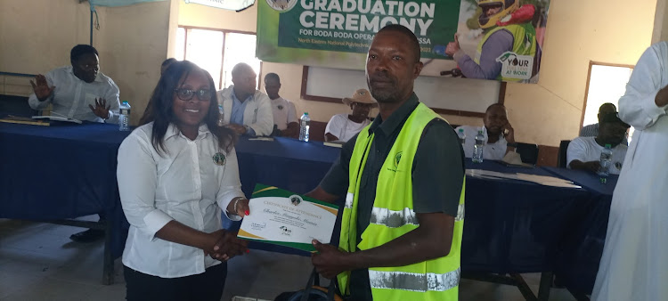 Charles Munyoki ,a bodaboda rider from Garissa is issued with a certificate after successfully completing the training that was carried out by the Kenya Roads Board.