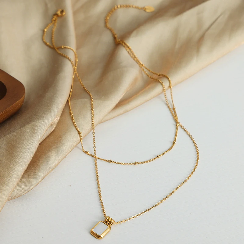 Collier chaîne de clavicule avec pendentif coquillage blanc en acier titane plaqué or, un bijou élégant et raffiné, cadeau idéal pour femme.