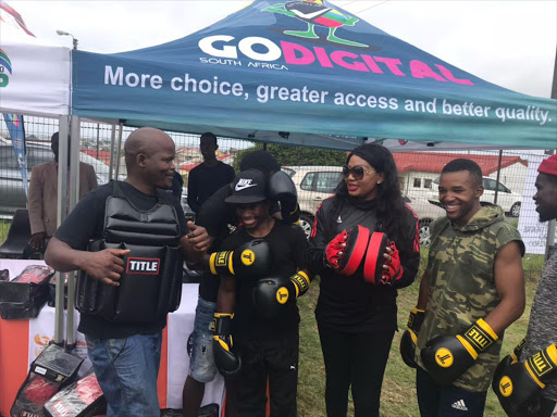 Deputy minister of Communications Tandi Mahambehlala with boxing golden boy Azinga Fuzile share a luagh during the deputy minister's visit to Duncan Village last weekend. Picture: Supplied