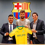 Barcelona star Gerard Pique holding Mamelodi Sundowns football jersey.