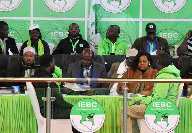 IEBC chief executive officer Marjan Hussein, chairman Wafula Chebukati and vice chairperson Juliana Cherera engage returning officers during the release of presidential results at constituency level at the Bomas of Kenya on August 13, 2022