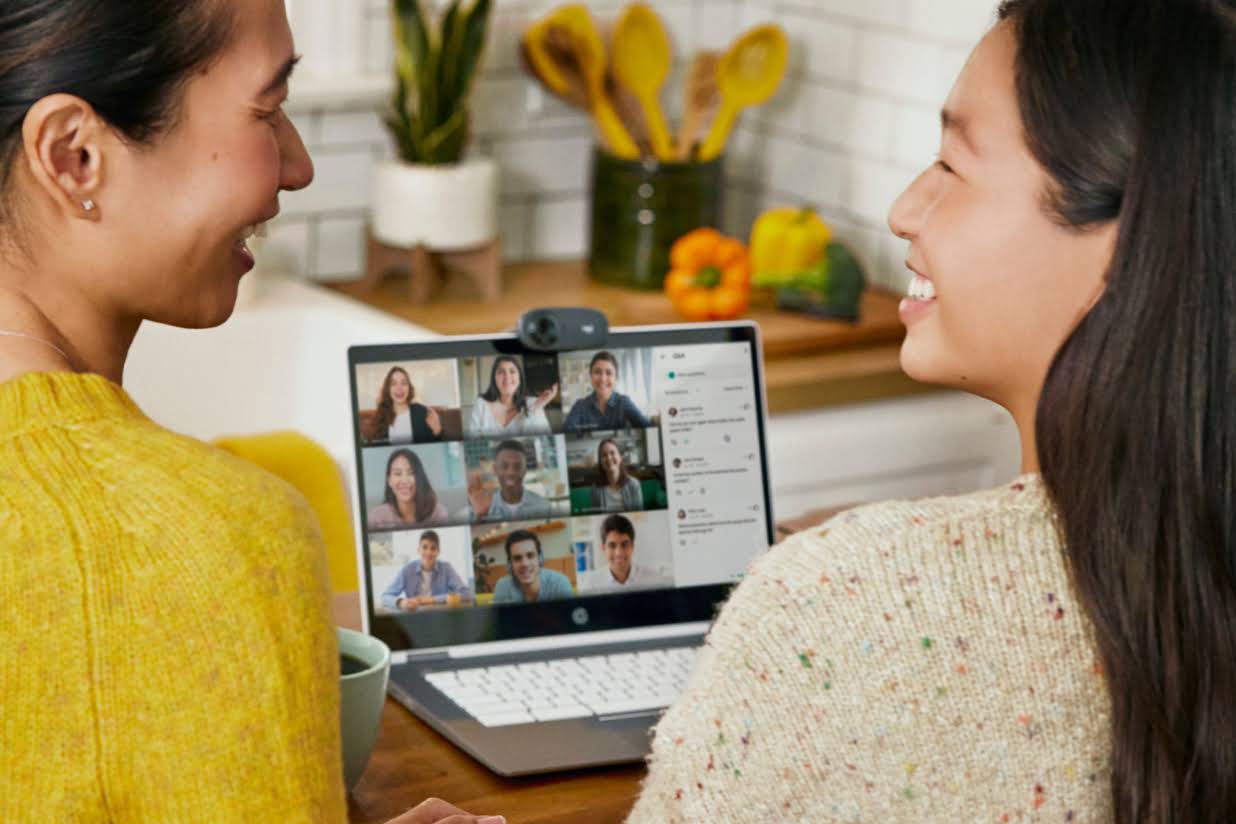 2 mensen lachen naar elkaar terwijl ze in de keuken zitten en deelnemen aan een Google Meet-gesprek.