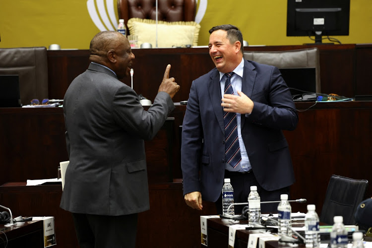 South African President Cyril Ramaphosa interacts with the leader of the opposition party, John Steenhuisen ahead of National Assembly members' questions in parliament in Cape Town, South Africa, November 3, 2022.