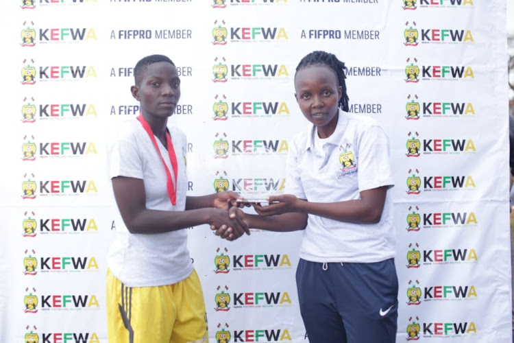 Vihiga Queens forward Terry Engesha receives the KWPL Player of the Year award from a KEFWA official in December 2019.