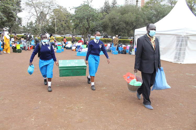 Peace Njeri, a Form 1 student (left) is escorted by her parent and a continuing student as she reports at Pangani Girls High School, Nairobi, on August 2, 2021