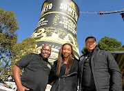 Soweto Gold founder and brew-master Ndumiso Madlala poses with Soweto  artist Karabo Poppy Moletsane  and former soccer ace Doctor Khumalo next to the Orlando cooling towers, now spotting Soweto Gold colours. / Veli Nhlapo