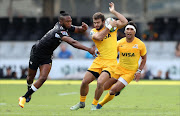 Sharks's Lukhanyo Am (L) tackles Jaguares Santiago Cordero (C) during the Super XV rugby union match between Sharks and Jaguares at Kingspark Rugby Stadium on April 8, 2017, in Durban.