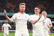 Kevin De Bruyne of Manchester City celebrates scoring his side's third goal with teammate Phil Foden in the Premier League against Wolverhampton Wanderers at Molineux in Wolverhampton on May 11 2022.