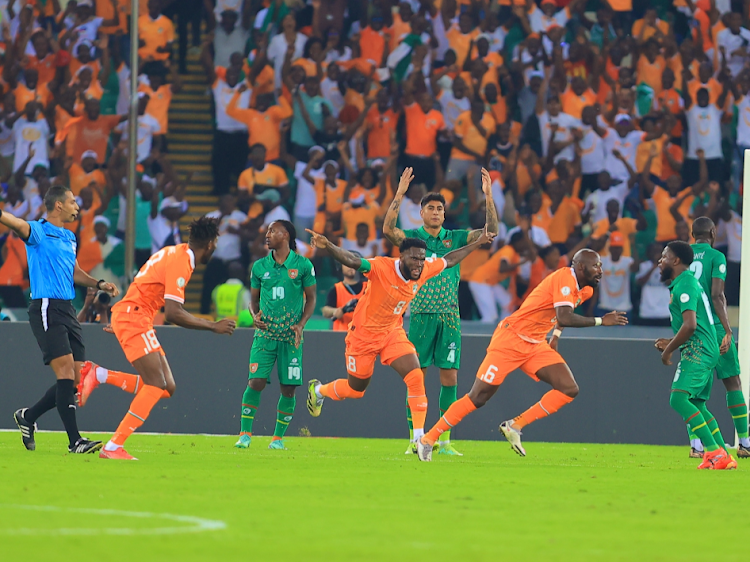 Ivory Coast players (in orange) celebrate after scoring against Guinea Bissau