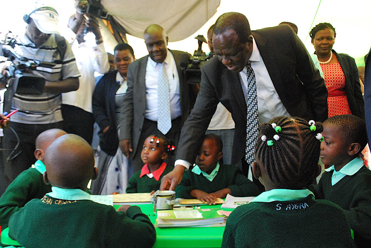 Kakamega governor Wycliffe Oparanya with the Kakamega primary school ECDE pupils as they take him through their learning process.