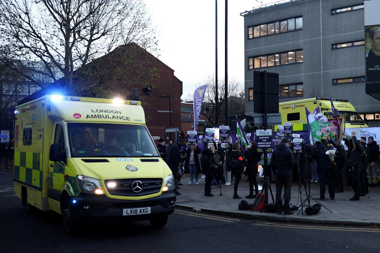 An ambulance drives past striking staff in outside the NHS London Ambulance Service offices in London, Britain, December 21 2022. Picture: HENRY NICHOLLS/REUTERS