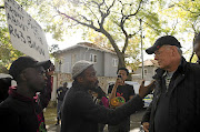 A  Black First Land First  member confronts former Business Day and Financial Mail editor  Peter Bruce outside his Johannesburg home yesterday over opinion pieces he wrote about the Gupta family.