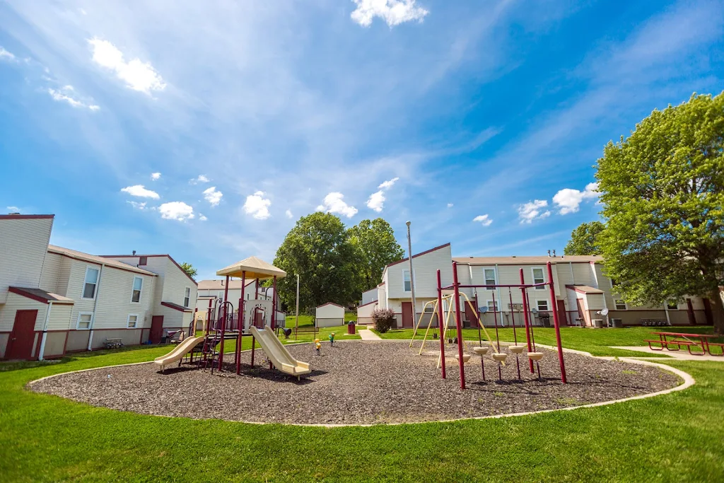 Outdoor playground area with slides, swings, and picnic tables