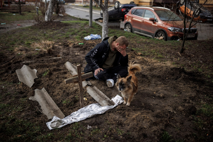 Serhii Lahovskyi, 26, mourns next to the grave of his friend Ihor Lytvynenko, who according to residents was killed by Russian soldiers, after they found him beside a building's basement, amid Russia's invasion of Ukraine, in Bucha, Ukraine on April 6 2022. Picture: REUTERS/ALKIS KONSTANTINIDIS