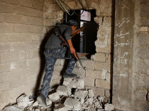 Iraqi Federal Police moves through a hole at Bab al Jadid district as the battle against Islamic State's fighters continues in the old city of Mosul, Iraq, March 26, 2017. /REUTERS