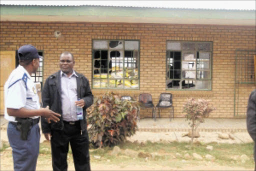 AFTERMATH: Maruleng mayor Pule Mafologele and a policeman assess the damage to the school. PHOTO: Madida John Seokoma