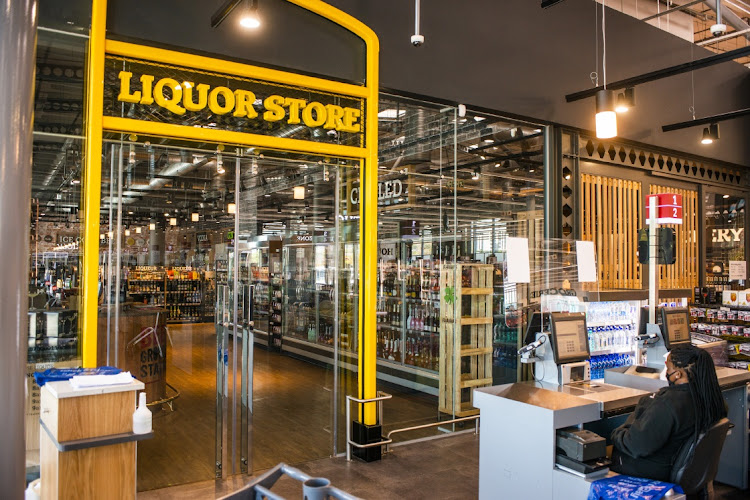 A cashier sits in front of a closed alcohol section in a Johannesburg Pick n Pay on Monday.