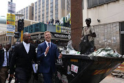 Controversial media personality  Gareth Cliff, seen here with his legal representative Dali Mpofu, went head-to-head with television channel M-Net in the Johannesburg High Court. They walk past 'waste picker' Oscar Maile after a session on the first day of court. Cliff was fighting for his job as an Idols judge, which he lost after he waded into the race debate that exploded after Penny Sparrow called black beachgoers 