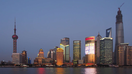 Shanghai-skyline-at-dusk - Wilson Hui: "This is a view of the Pudong area from across the Huang Pu river on the Bund. You really don't get a good sense of scale here, but the Jin Mao Tower used to be the tallest building in China until the Shanghai World Financial Tower came along. Soon it'll be dwarfed by the Shanghai Tower seen under construction here."