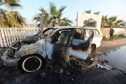 A person looks at a vehicle where employees from the World Central Kitchen (WCK), including foreigners, were killed in an Israeli airstrike, according to the NGO as the Israeli military said it was conducting a thorough review at the highest levels to understand the circumstances of this 