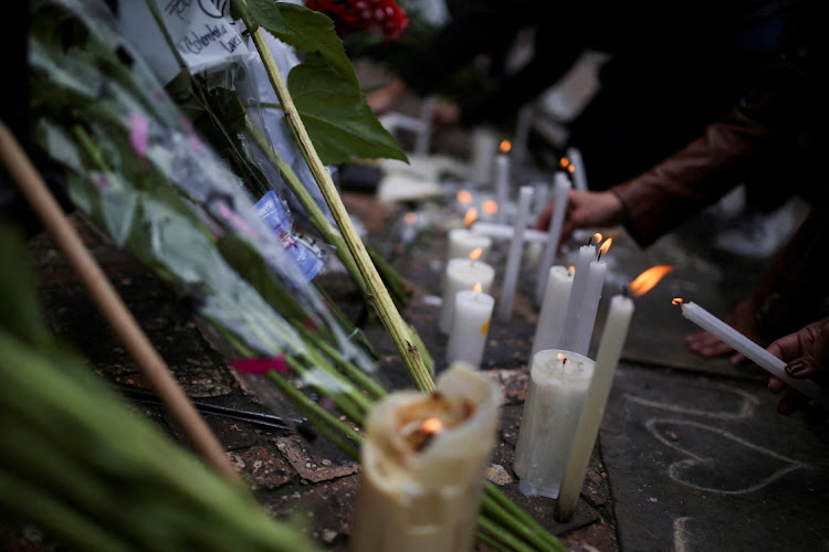 People light candles outside the Casa Medina hotel where Taylor Hawkins, the band's drummer, died before appearing at the Estereo Picnic festival in Bogota, Colombia.