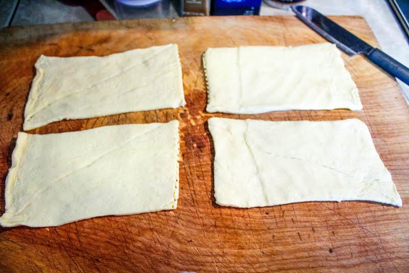 Crescent Dough Unrolled And In Quarters.