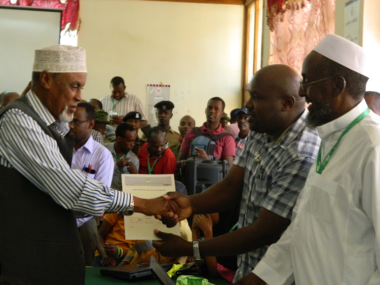 Garissa senator Yussuf Haji being awarded a certificate by the county returning officer in august 2017 after he won the senator seat.