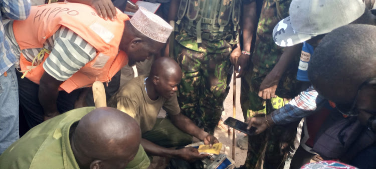 Police officers and rescue team comb through the documents of one of the victims of the ill fated boat.