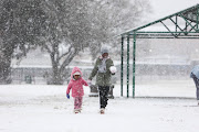 From left: Sisters Onalenna and Thoriso Monama play in the snow,  10 July 2023, at Jackson Dam in Alberton, South of Johannesburg.  